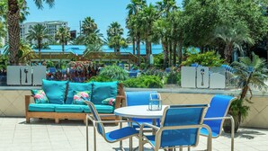 Un espace patio avec un canapé turquoise, des chaises bleues et une table ronde.