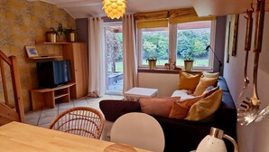 A cozy living room with a television, sofa, and dining table. - Lovely apartment on the Wadden Sea, suitable for children and tierlieb♥️ (Wangerland)