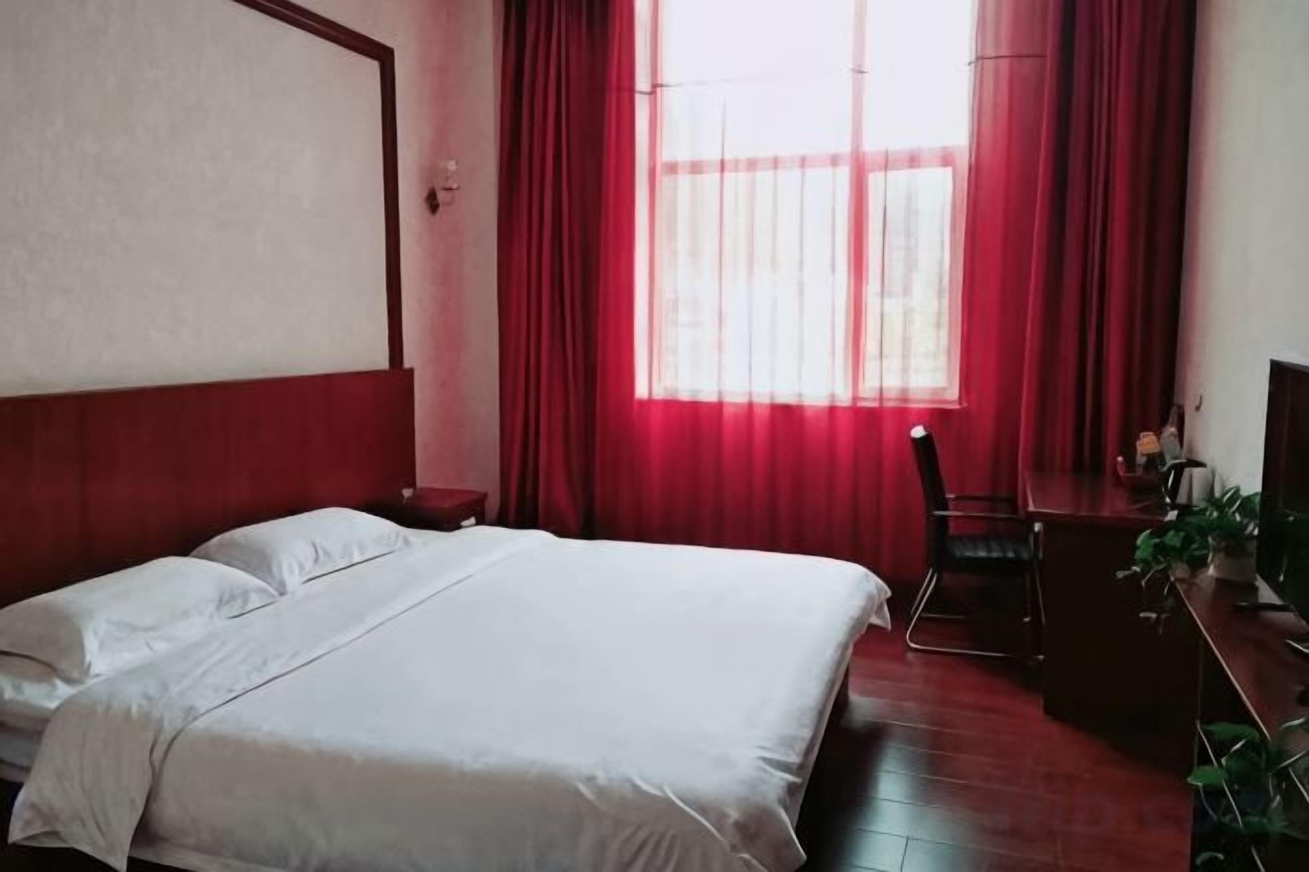 Una habitación de hotel con una cama, un escritorio y una silla.