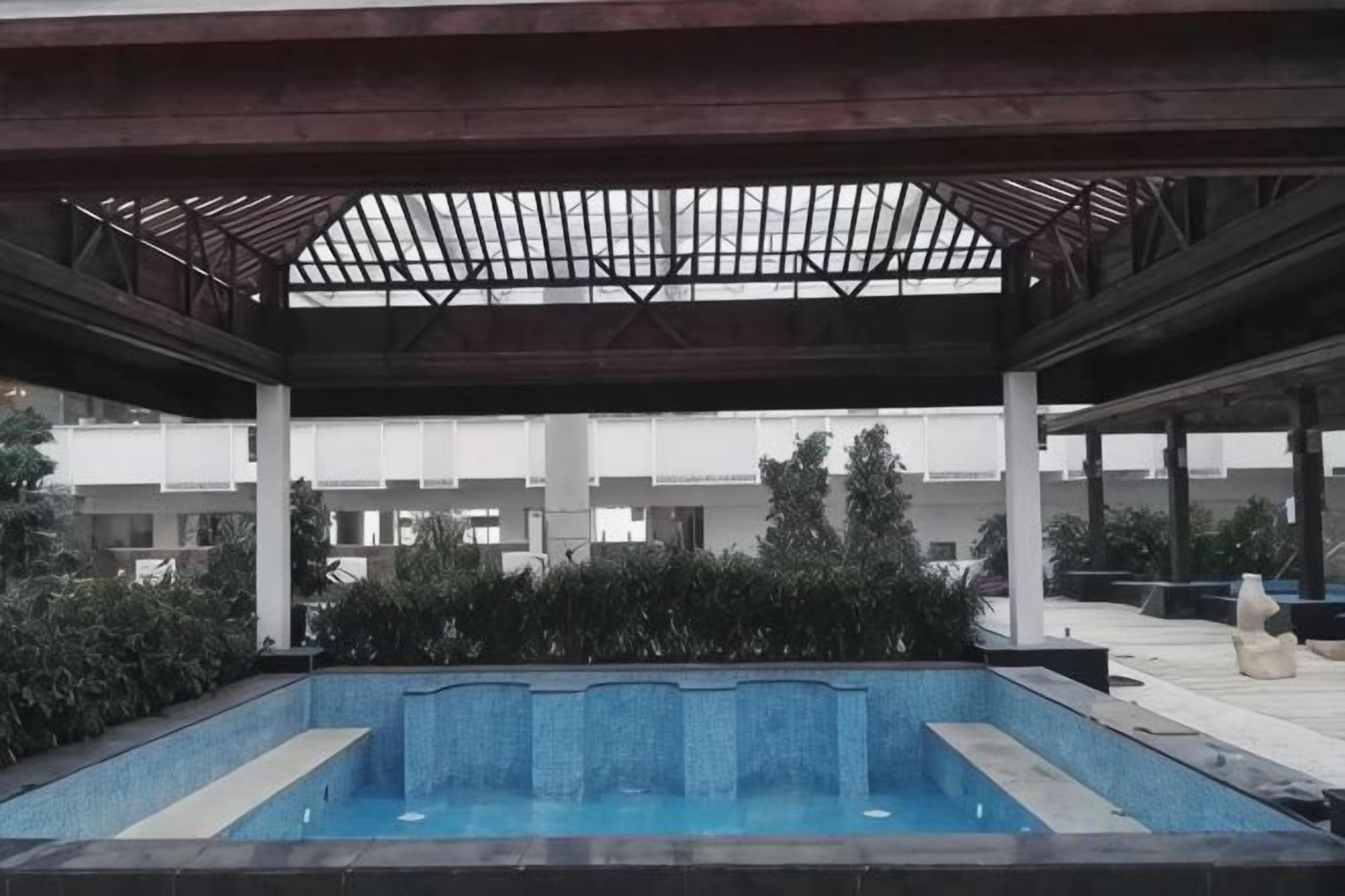 A covered swimming pool with a view of a modern building in the background.