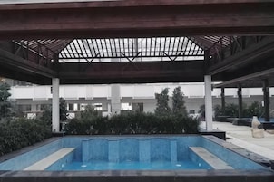Una piscina techada con vistas a un edificio moderno al fondo.