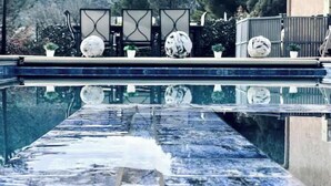 Une piscine offrant une vue dégagée sur le paysage environnant, notamment sur une montagne et une clôture agrémentée d’éléments décoratifs.
