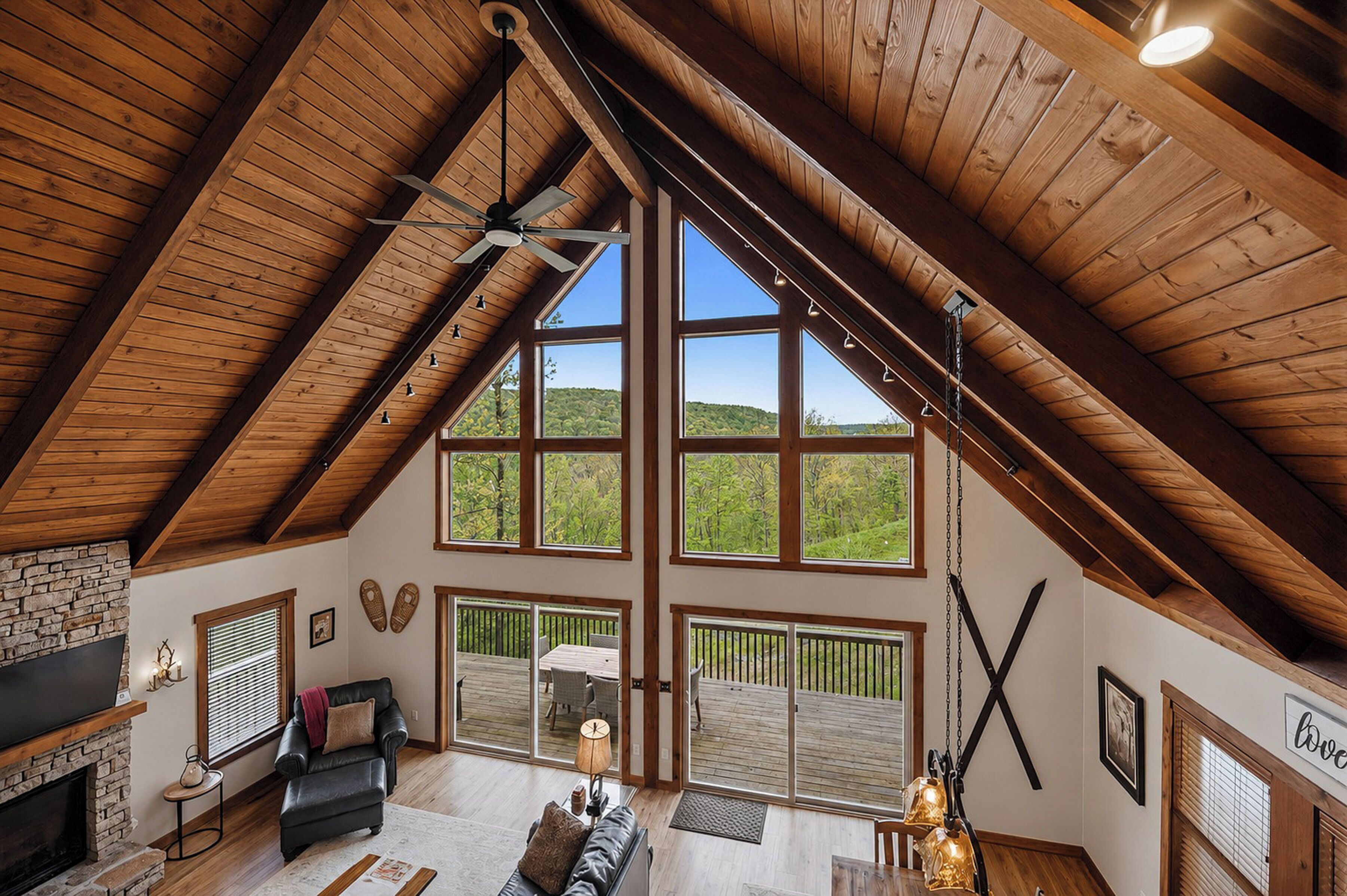 A spacious loft with a high ceiling, large windows, a fireplace, and a cozy seating area. - Fireplace Deck, Game Room & Mountain Vibes (McHenry)