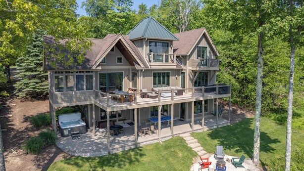 A two-story house with a covered patio, outdoor seating, and a hot tub. - Stunning Views & Dog Friendly Style w/ Hot Tub (McHenry)