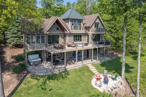 A two-story house with a covered patio, outdoor seating, and a hot tub. - Stunning Views & Dog Friendly Style w/ Hot Tub (McHenry)