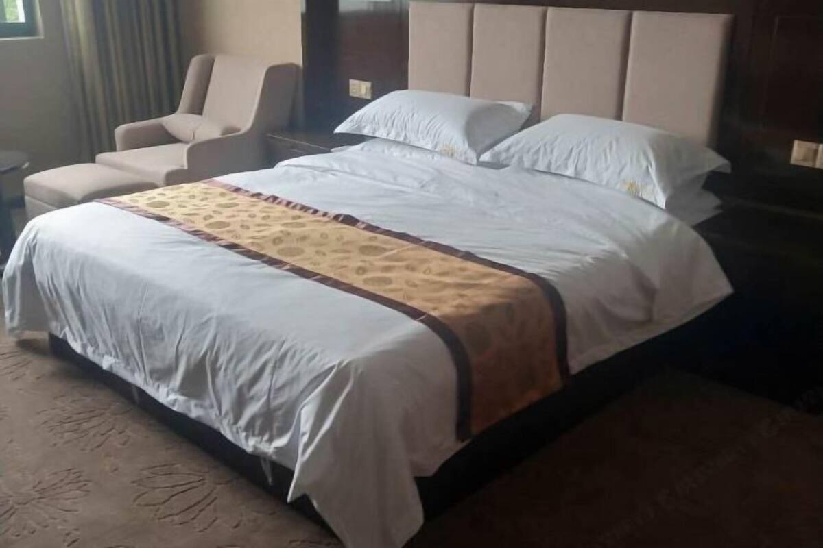 Une chambre d’hôtel avec un grand lit, une chaise et une table de chevet.