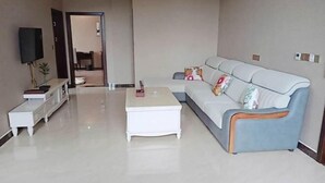 Ein modernes Wohnzimmer mit einer Couch, einem Couchtisch und einem Fernseher.