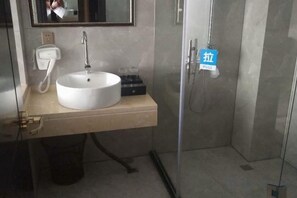 Un baño con lavamanos, espejo y ducha.
