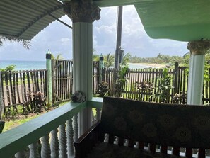 A covered outdoor area with a view of the beach and ocean.