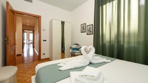 Une chambre d’hôtel avec un lit, une chaise, un bureau et une porte donnant sur un balcon.