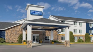 A City Express by Marriott hotel with a stone facade, a covered entrance, and a clear blue sky. - City Express by Marriott Bemidji (Bemidji)