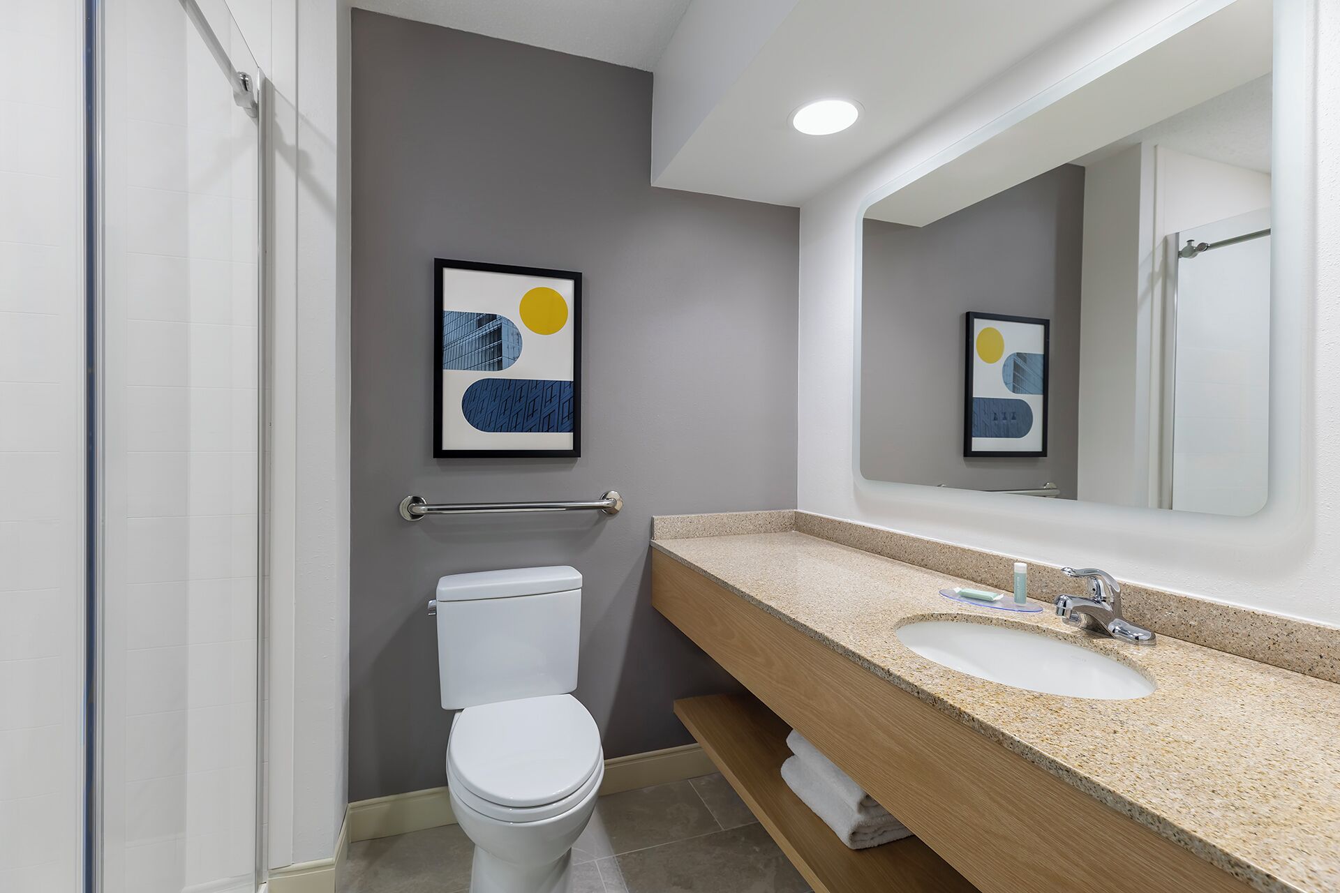 A modern bathroom with a toilet, sink, and shower.