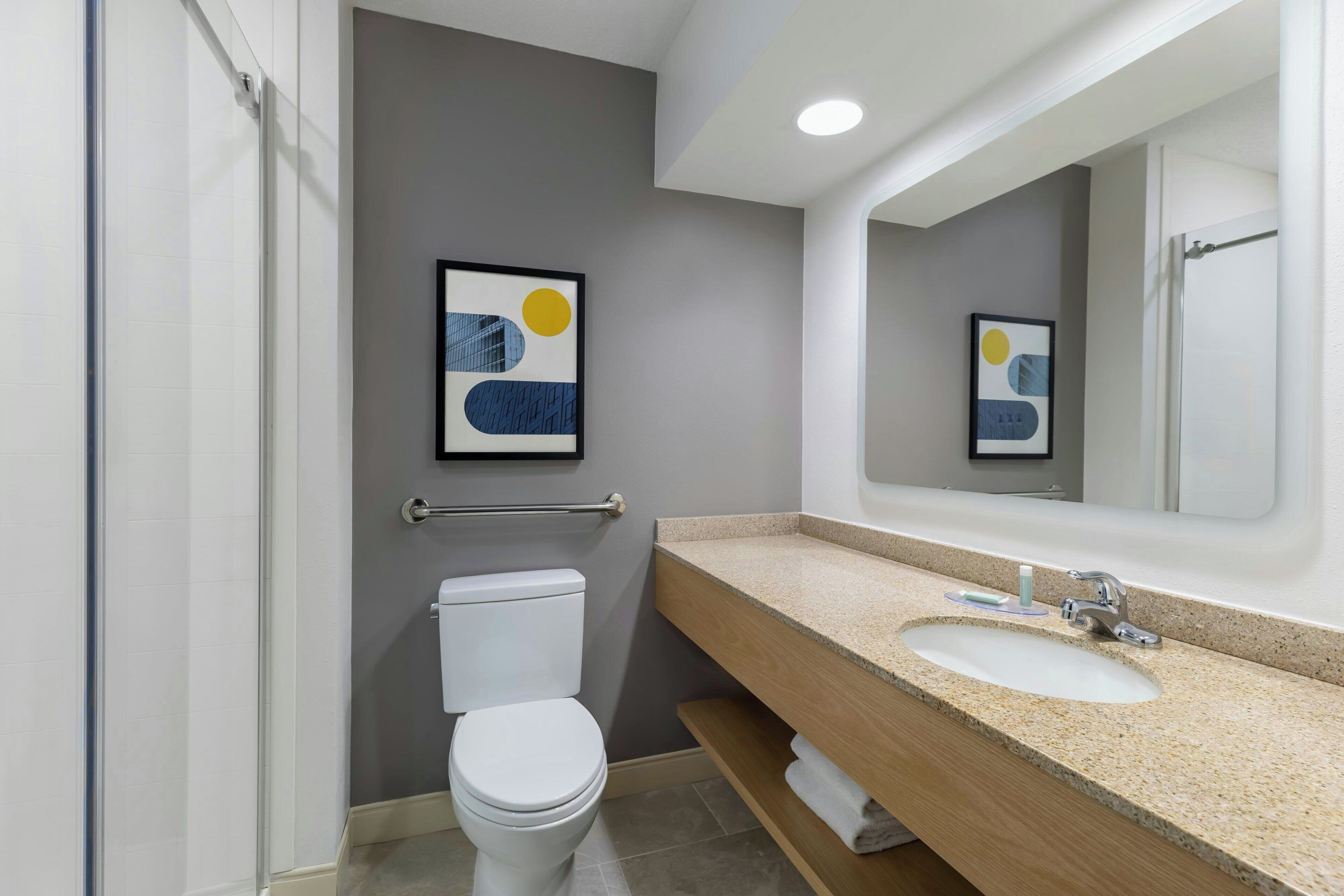 Un baño moderno con inodoro, lavamanos y ducha.