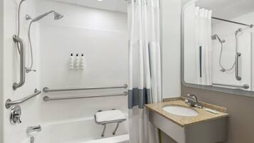 A modern bathroom with a bathtub, shower, and sink.