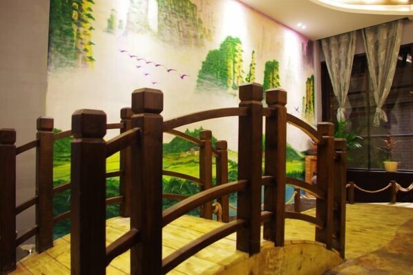 A wooden staircase with a view of a mural depicting a landscape. - Huatianju Inn (Zhangjiajie)