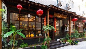 A traditional building with wooden architecture, large windows, and red lanterns. - Huatianju Inn (Zhangjiajie)