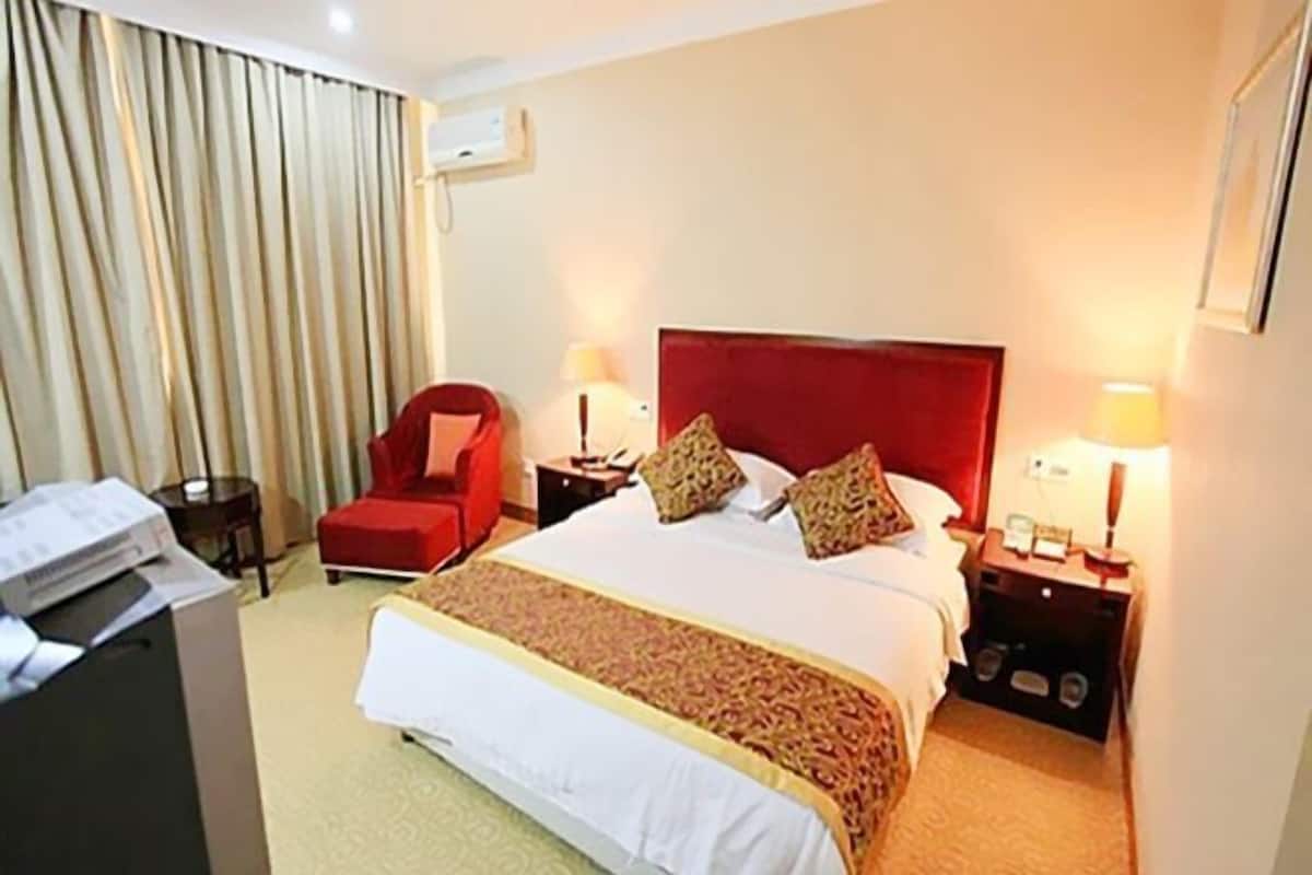 Relax in this inviting space with a large bed, a comfortable armchair, and a convenient table.