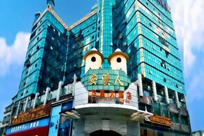 A building with a distinctive facade featuring a large, cartoonish face with eyes and a mouth. - Huaxia Hotel (Anxi)