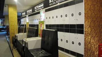 A billiards club with black and white lockers, black cushioned seating, and a patterned wall.