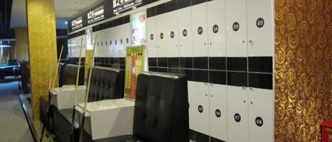 A billiards club with black and white lockers, black cushioned seating, and a patterned wall.