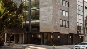 Un immeuble moderne à plusieurs étages, doté d’une façade en verre et d’une structure extérieure en béton.