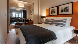 A hotel room with a large bed, a desk, and a chair. There is a dining area visible through an open door. - Newly-Renovated Studio in a 1920's Modern House (Ciudad de México)