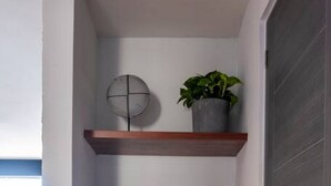Un couloir étroit, doté d’étagères en bois où sont exposés des objets décoratifs, et d’un panier en osier.