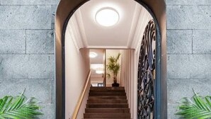 Una scala con ringhiera in metallo che conduce a una stanza illuminata da una luce a soffitto.