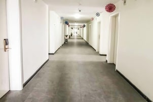 Un largo y estrecho pasillo de hotel con puertas a ambos lados y un pasillo central.