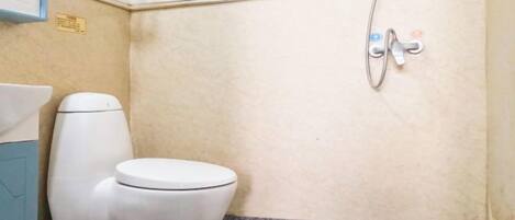 A small bathroom with a toilet, a sink, and a shower.