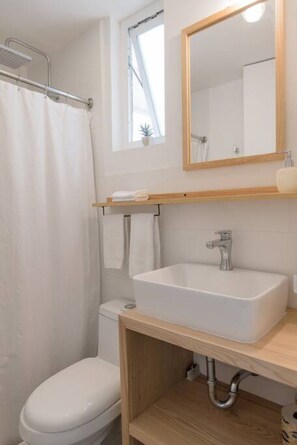 Ein Badezimmer mit Dusche, Toilette und Waschbecken.