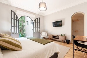 Une chambre moderne équipée d’un lit, d’une télévision, d’un bureau et d’une armoire.