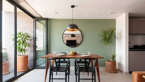 A dining area with a wooden table, black chairs, and a large pendant light.