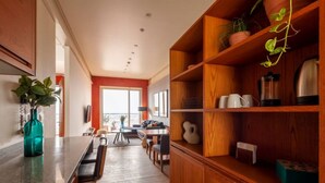 A modern kitchen with wooden cabinets, a dining area with a table and chairs, and a view through a large window. - Enjoy skyline/city views from this 17th floor flat (Ciudad de México)