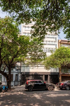 A street scene with parked cars, trees, and a building with multiple windows. - Mayan Sparrow, Stylish Apartment in Casa Quetzal (Ciudad de México)