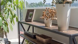 A wooden table with a potted plant, a framed picture, and a woven basket. - Darwin's Garden an amazing flat in Casa Quetzal (Ciudad de México)