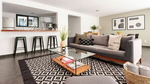 A modern living room with a grey sofa, black and white patterned rug, and a glass coffee table. - Modern, Industrial Apartment with Bamboo Garden and Rooftop Terrace (Ciudad de México)