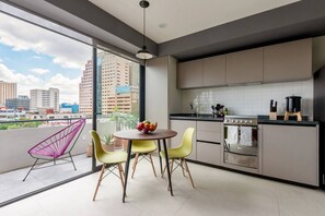 Une cuisine moderne avec un coin repas, de grandes fenêtres et une vue sur la ville.