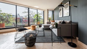 A modern living room with a sofa, a coffee table, and a floor lamp. - Bright Luxurious 2 BDR Flat at Corner Condesa (Ciudad de México)