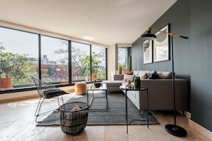 Un salon moderne avec un canapé, une table basse et un lampadaire.