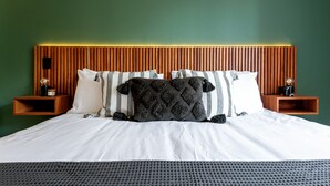 A bed with white bedding, a dark gray throw, and striped pillows against a green wall. - Bright Luxurious 2 BDR Flat at Corner Condesa (Ciudad de México)