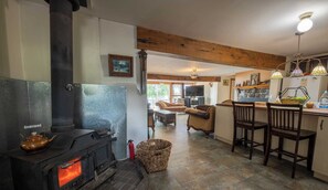 Cozy living area with a fireplace, comfortable seating, and a kitchen area.