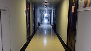 A long, narrow hallway with doors on both sides, leading to rooms. - Aishang Yihao Apartment (Zhangjiajie)