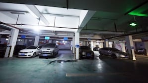 A multi-level parking garage with several cars parked. - Aishang Yihao Apartment (Zhangjiajie)