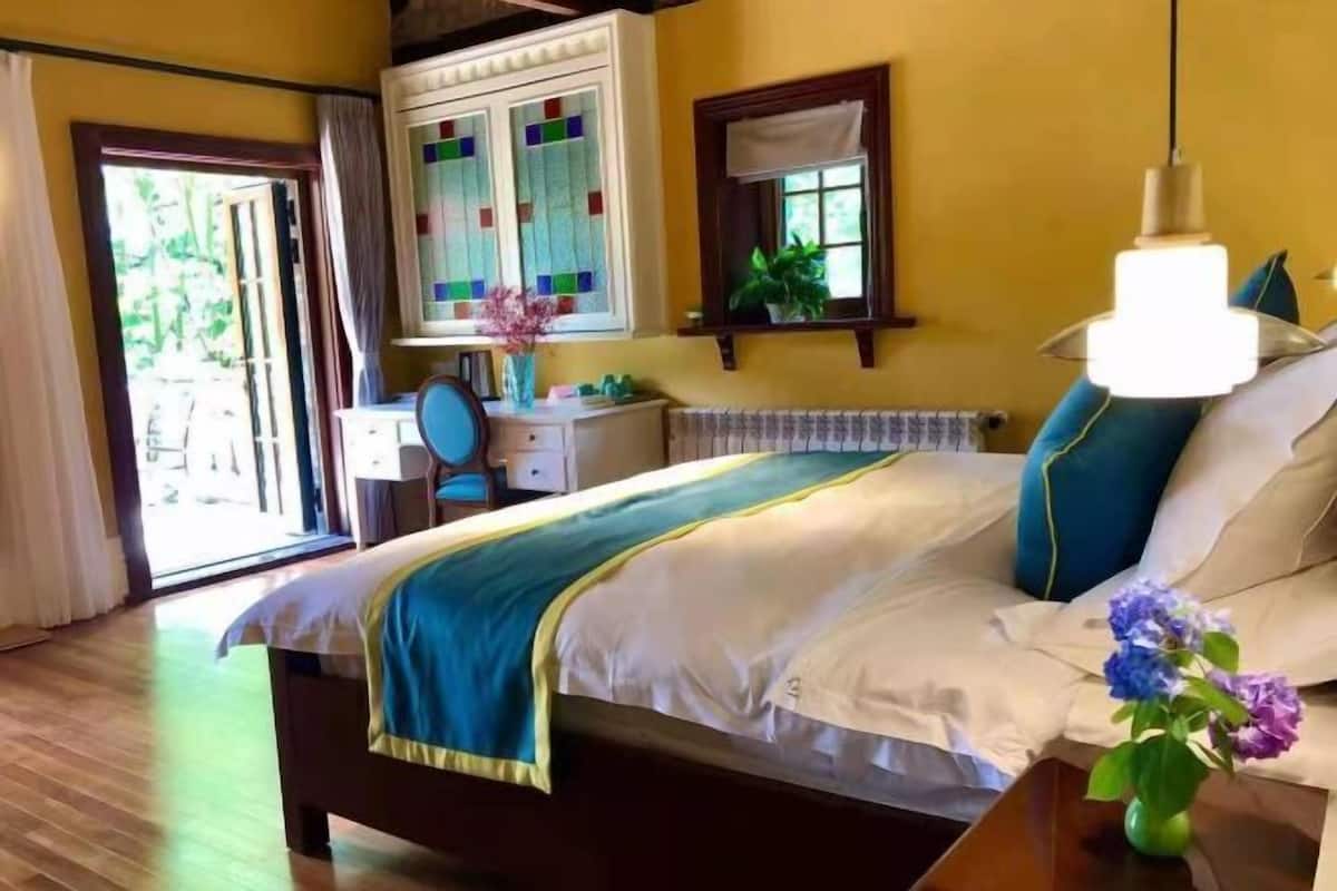 Une chambre à coucher avec un lit, une commode, un miroir et une fenêtre.