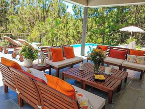 Relax by the pool surrounded by lush greenery and enjoy dining or seating on the patio.