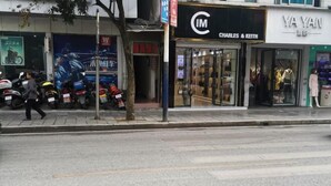 Une vue de rue avec des devantures de magasins, notamment un magasin Charles & Keith et un magasin Ya Yan.