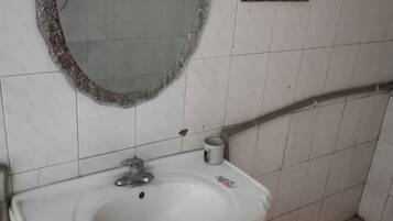 A bathroom with a white sink, a mirror, and a towel rack.