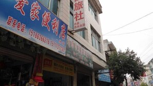 Un immeuble sur lequel on peut voir plusieurs enseignes, dont une pour un hôtel et une autre pour une agence de voyages.