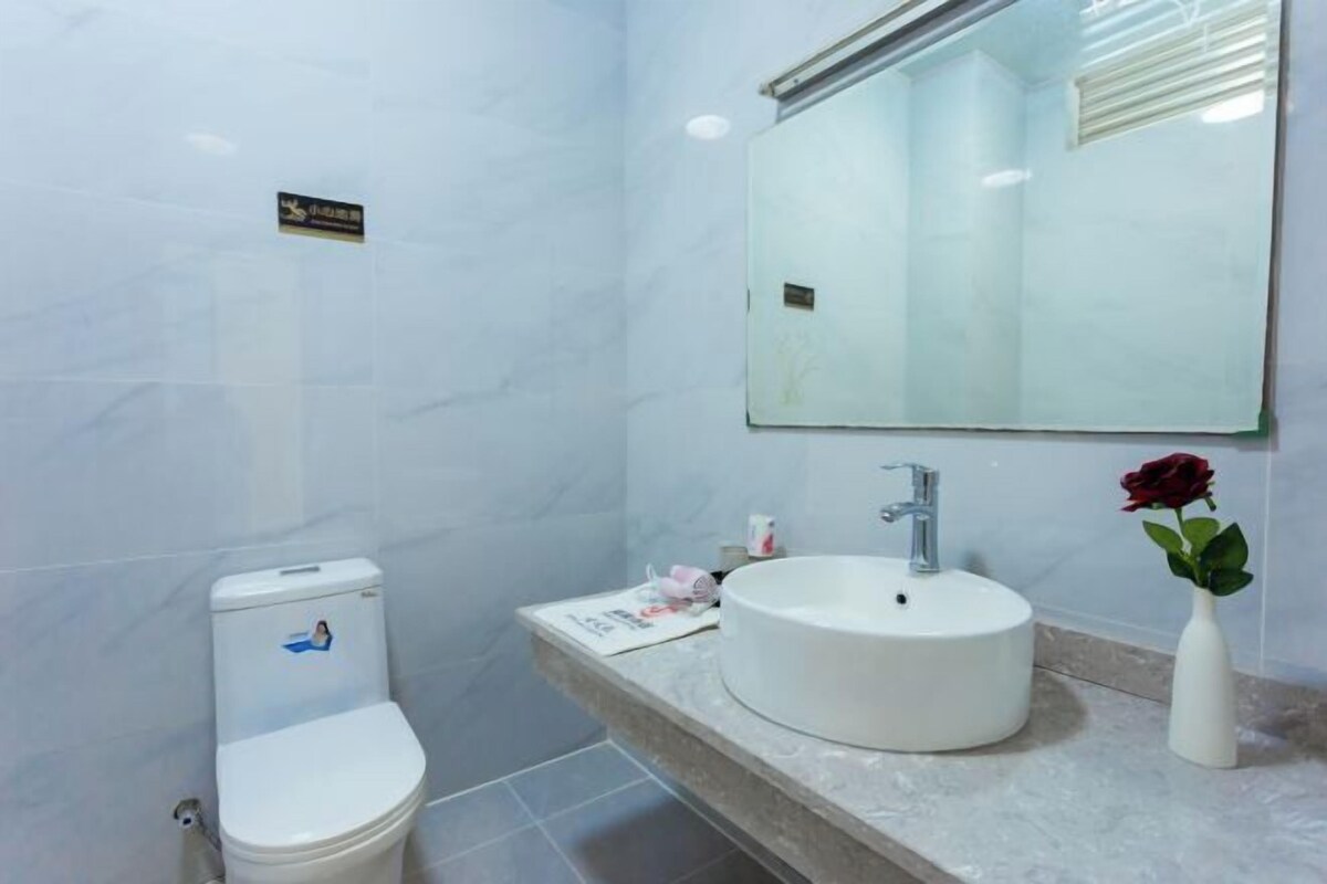 A bathroom with a toilet, a sink, and a mirror.